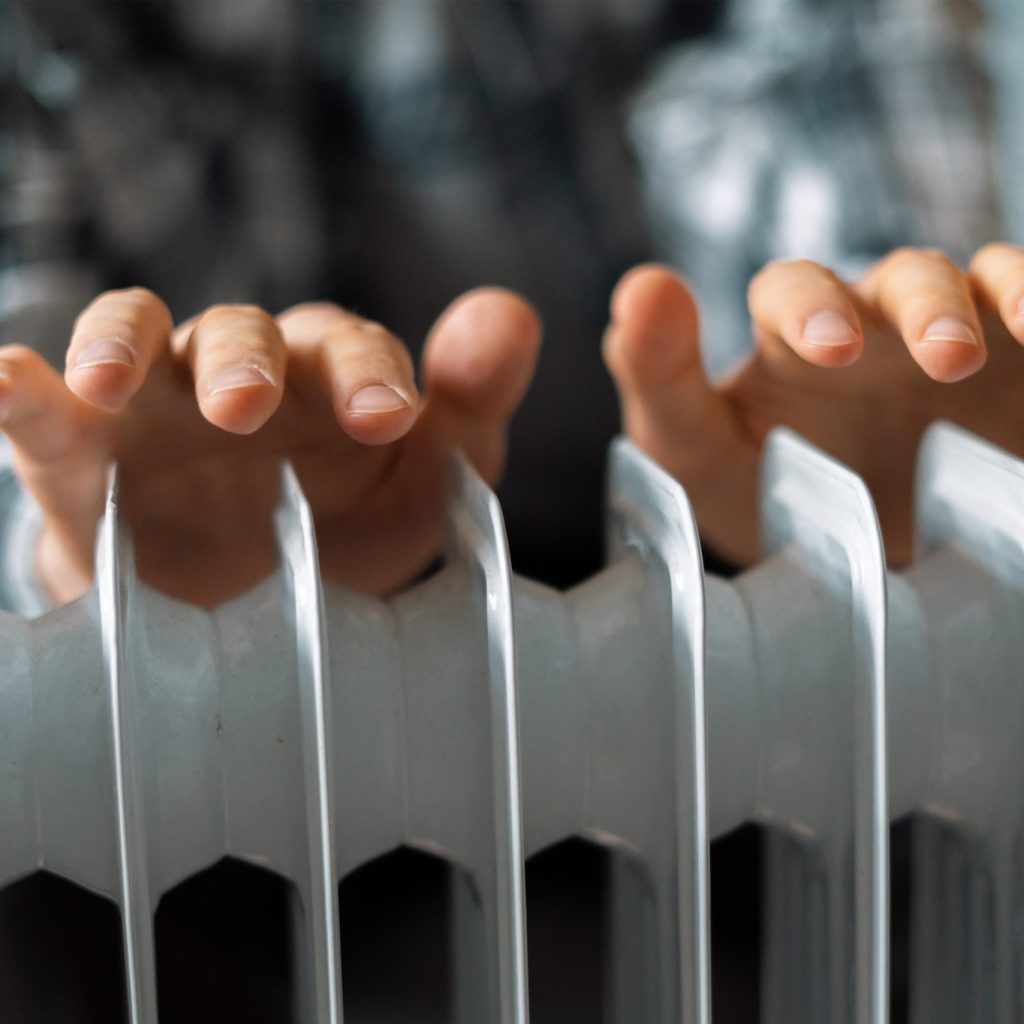 feeling cold, getting warm, hands touching the heater close up
